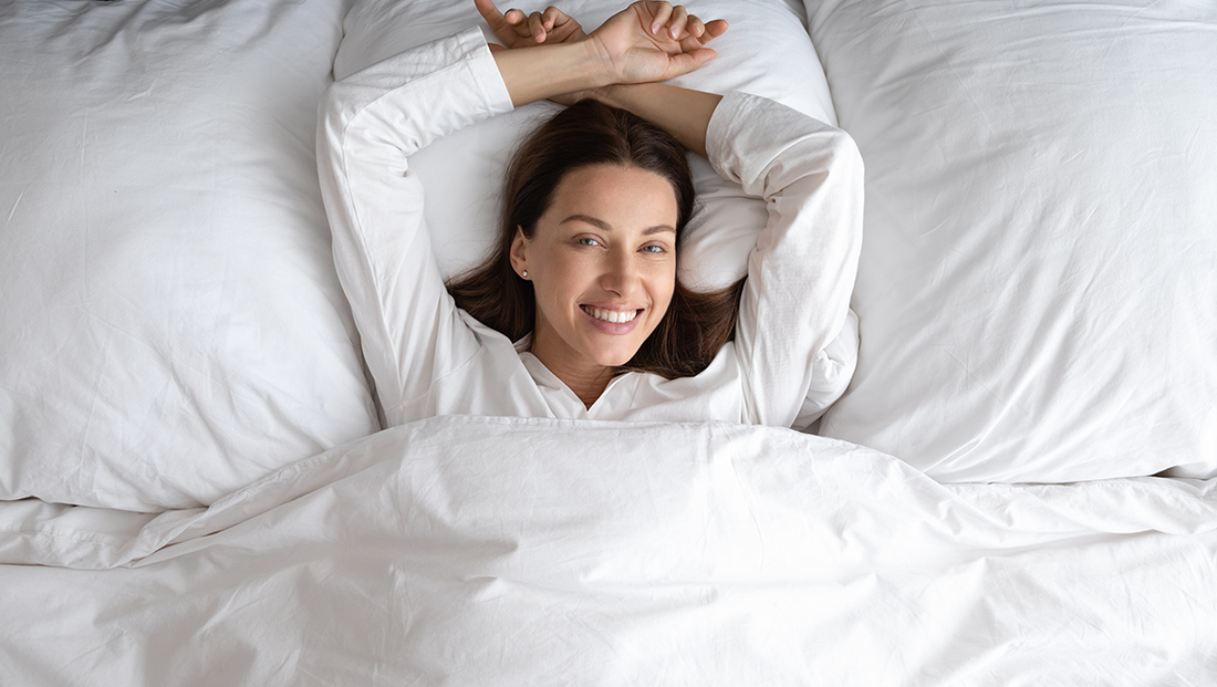 Γυναίκα απολαμβάνει ξεκούραστο ύπνο σε λευκά σεντόνια, ιδανική στάση ύπνου με στήριξη από στρώμα ORION Strom