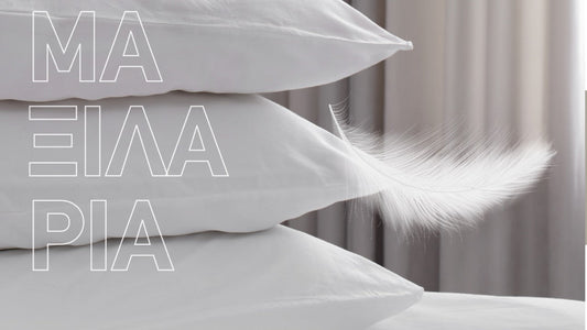 Λευκά μαξιλάρια στοιβαγμένα με πούπουλο που αιωρείται