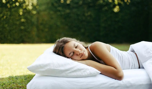 Γυναίκα κοιμάται γαλήνια σε λευκό μαξιλάρι σε εξωτερικό χώρο